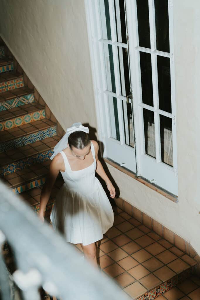 modern bride with short wedding dress coming down the stairs
