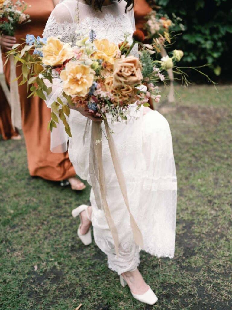 blurred view of bride with bouquet featuring toffee roses, romantic wedding details