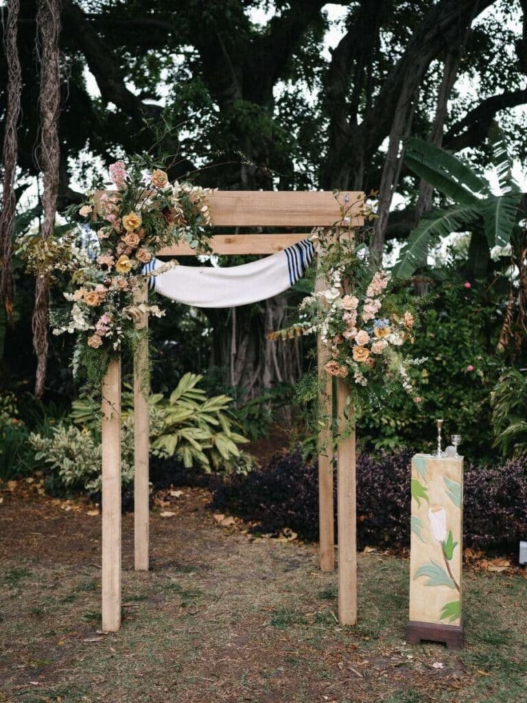 outdoor wedding ceremony setup with wooden chuppah and nature-inspired florals in miami, fl