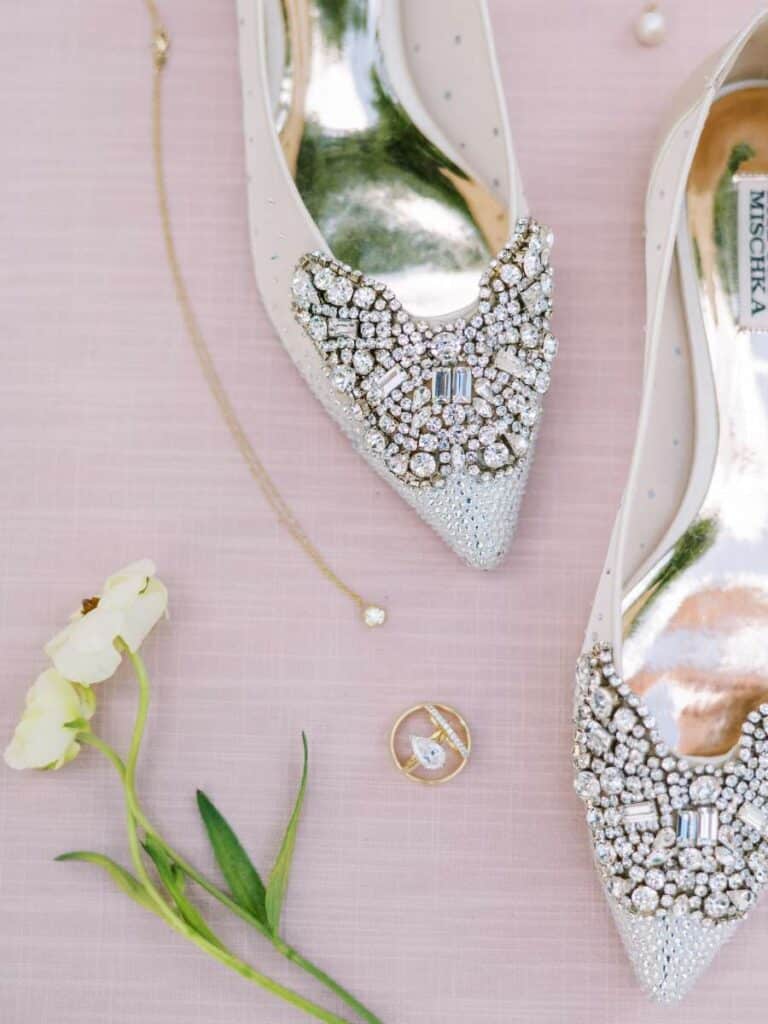 sparkly bridal shoes with wedding jewelry and a fresh sprig of flowers