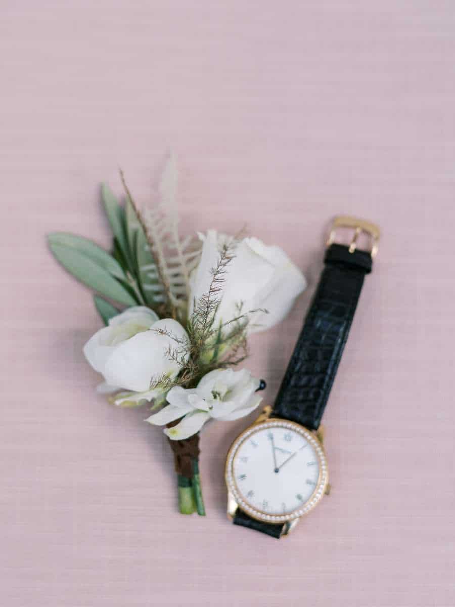 groom's boutonniere and watch on pink linen for a vizcaya garden wedding