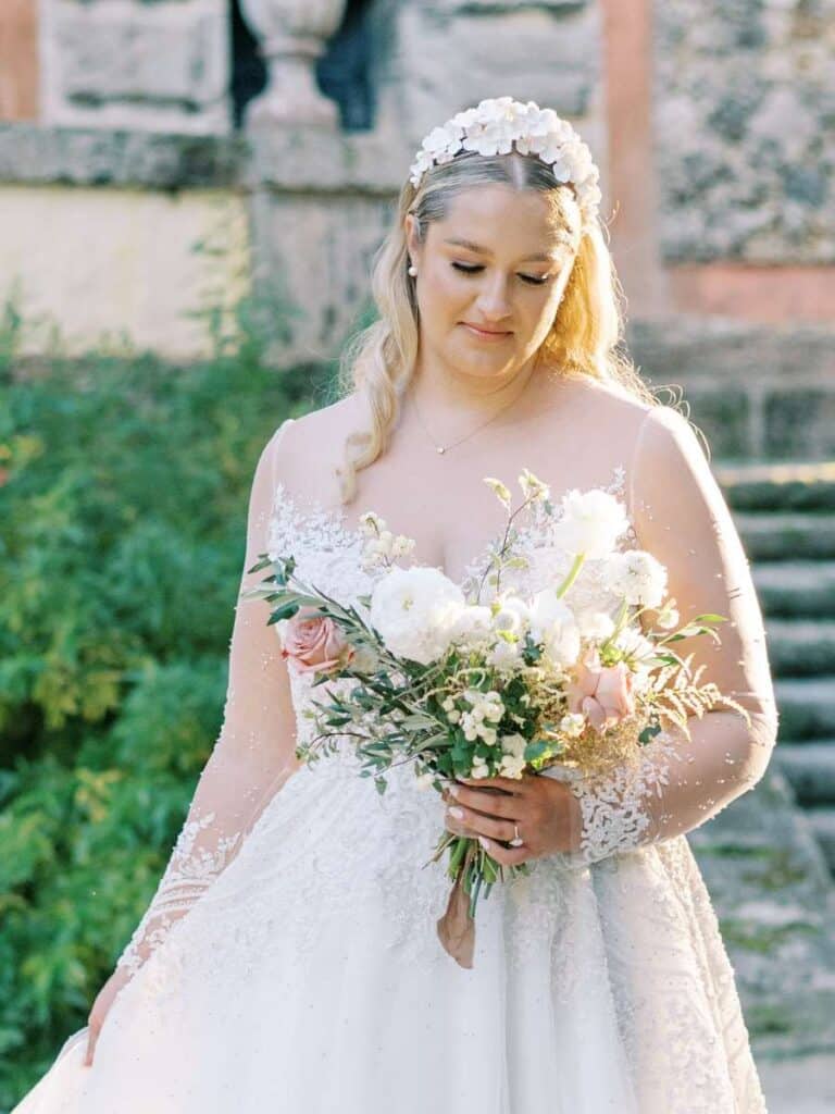 bride holding a white floral bouquet at vizcaya with a serene expression