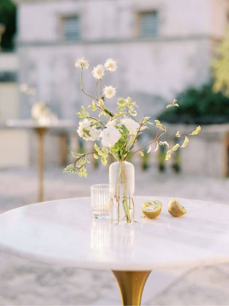 minimalistic wedding centerpiece with white flowers on a golden stand